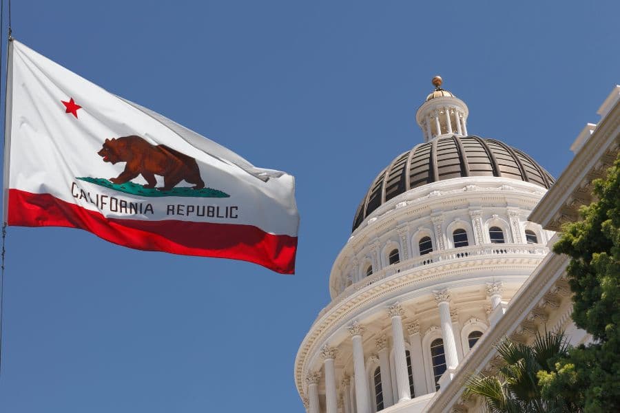 California state flag waves over the state capital building where Gov. Newsom signed CA SB 40 into law