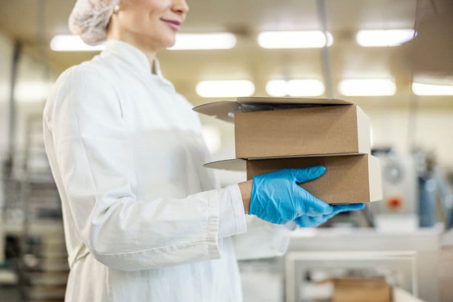 Person carrying packaging boxes for assessment