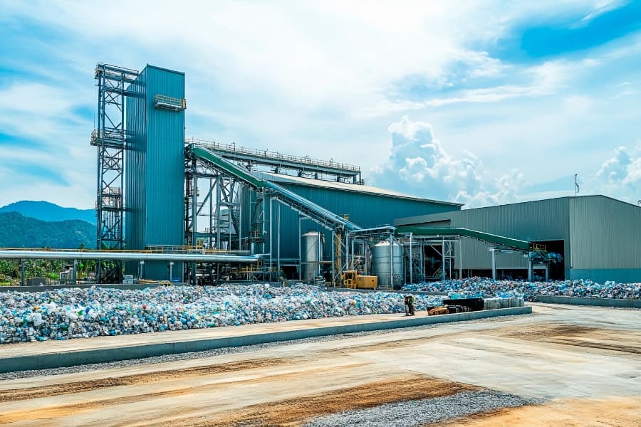Recycling Center looms under a blue sky with mountains in the background.
